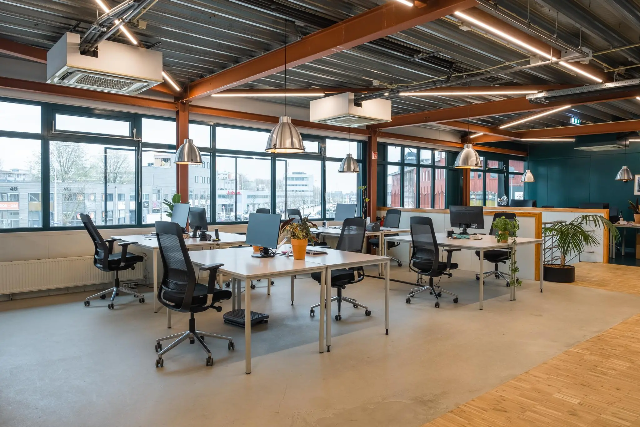 Modern kantoorinterieur aan de Johan van Hasseltweg met open werkplekken, bureaustoelen en grote ramen.